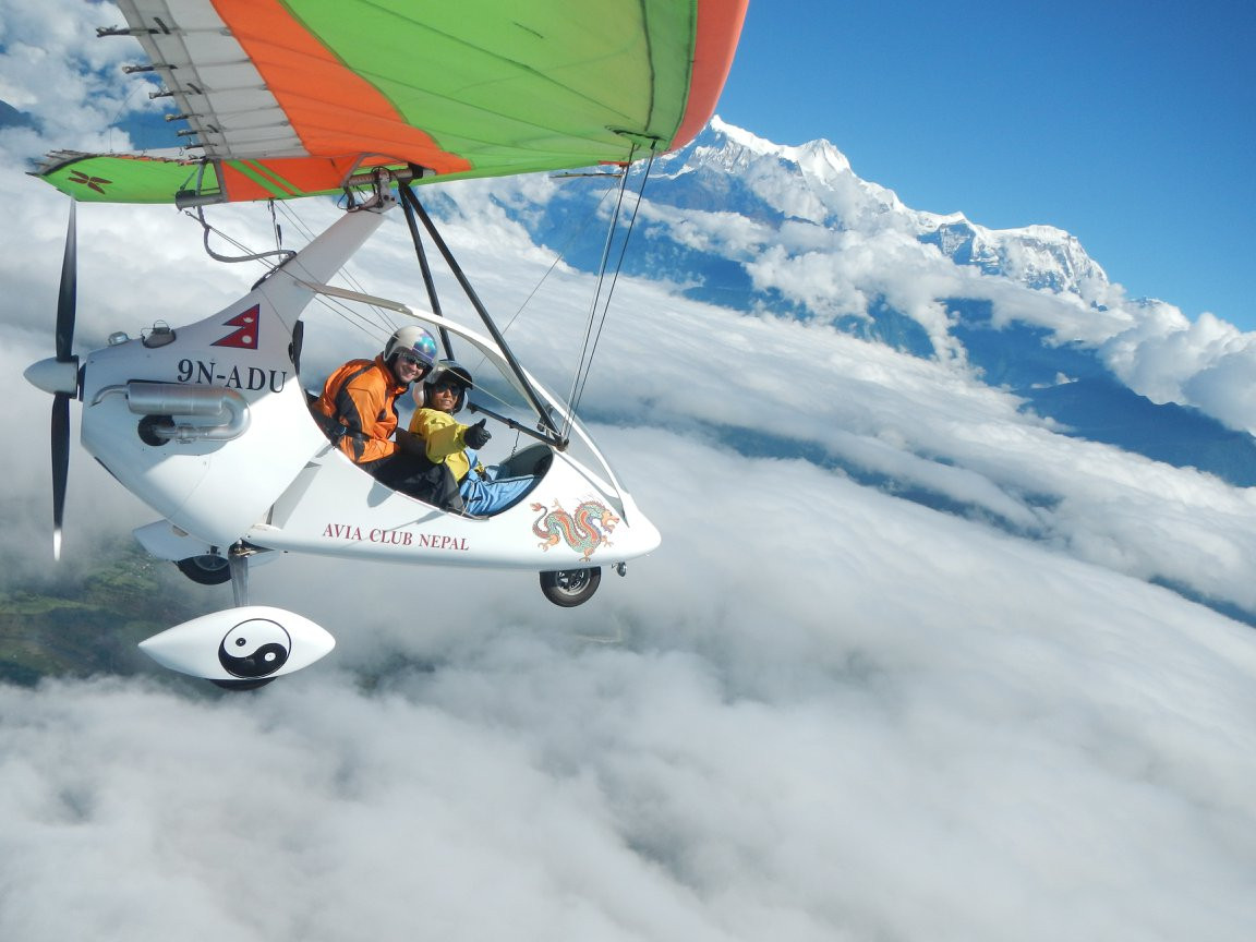 Guest from North Nepal Travel flying above the clouds, near the Himalayas on an ultralight flying in Pokhara.